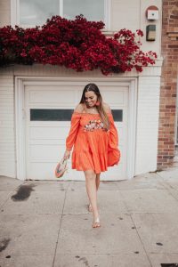 Ashley Zeal from Two Peas in a Prada wears an orange off the shoulder Free People dress and shares the best summer dresses.