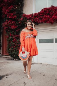 Ashley Zeal from Two Peas in a Prada wears an orange off the shoulder Free People dress and shares the best summer dresses.